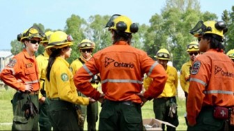 Photo of several firefighters in a field standing in a circle conferring