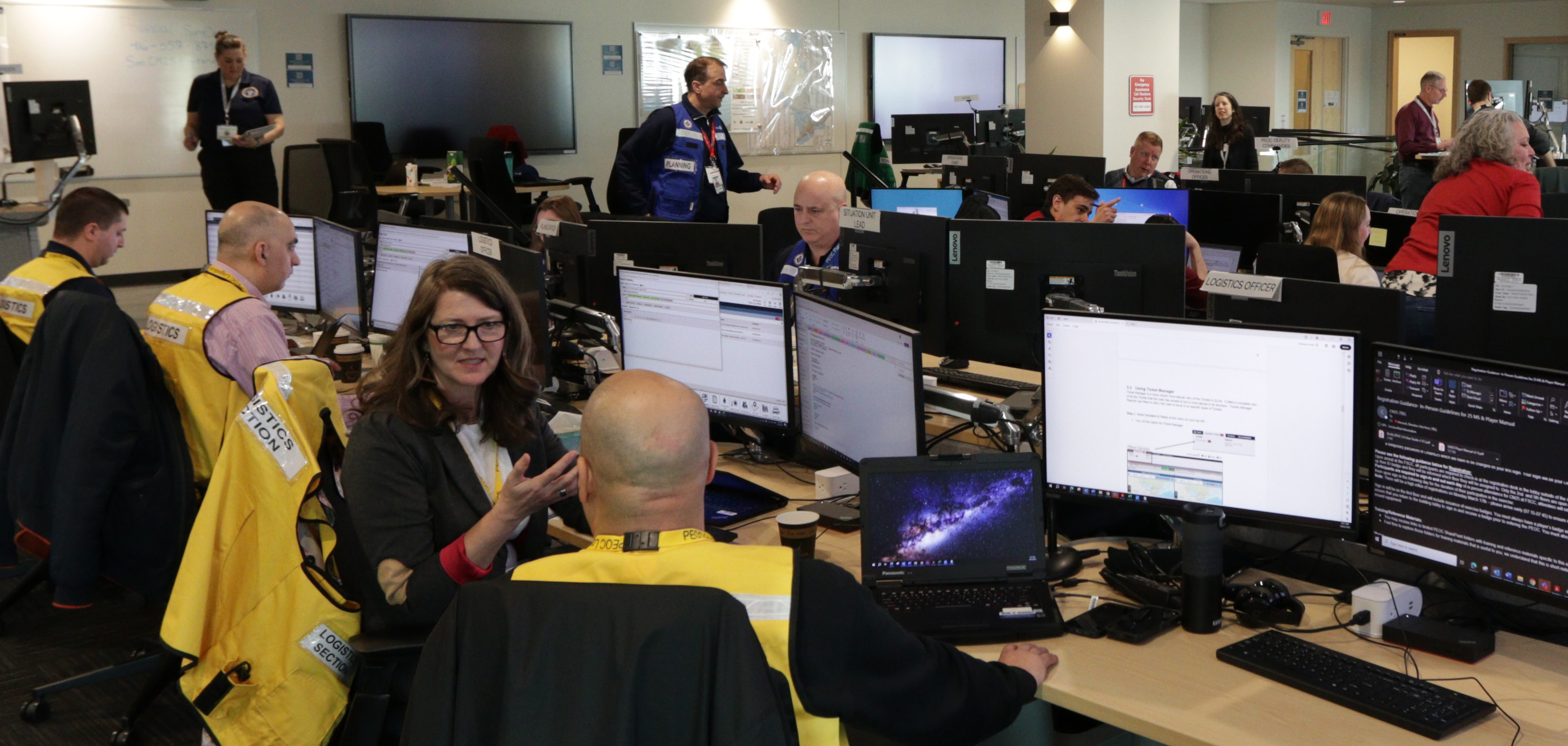 A group of people talking and checking monitors