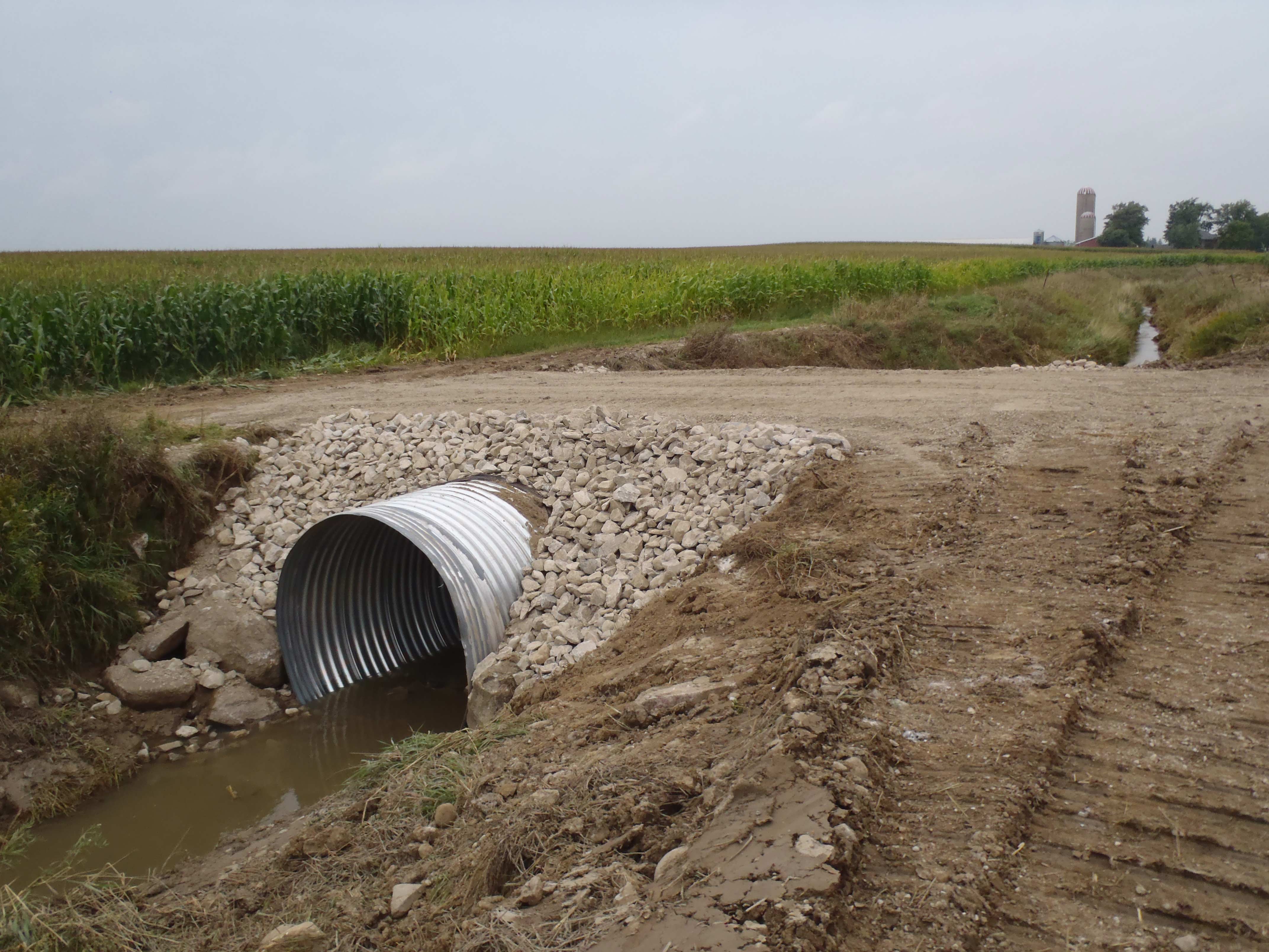 Photo montrant un nouveau ponceau installé dans un drain qui permet au propriétaire foncier de traverser le drain pour passer de la route jusqu’à sa propriété agricole