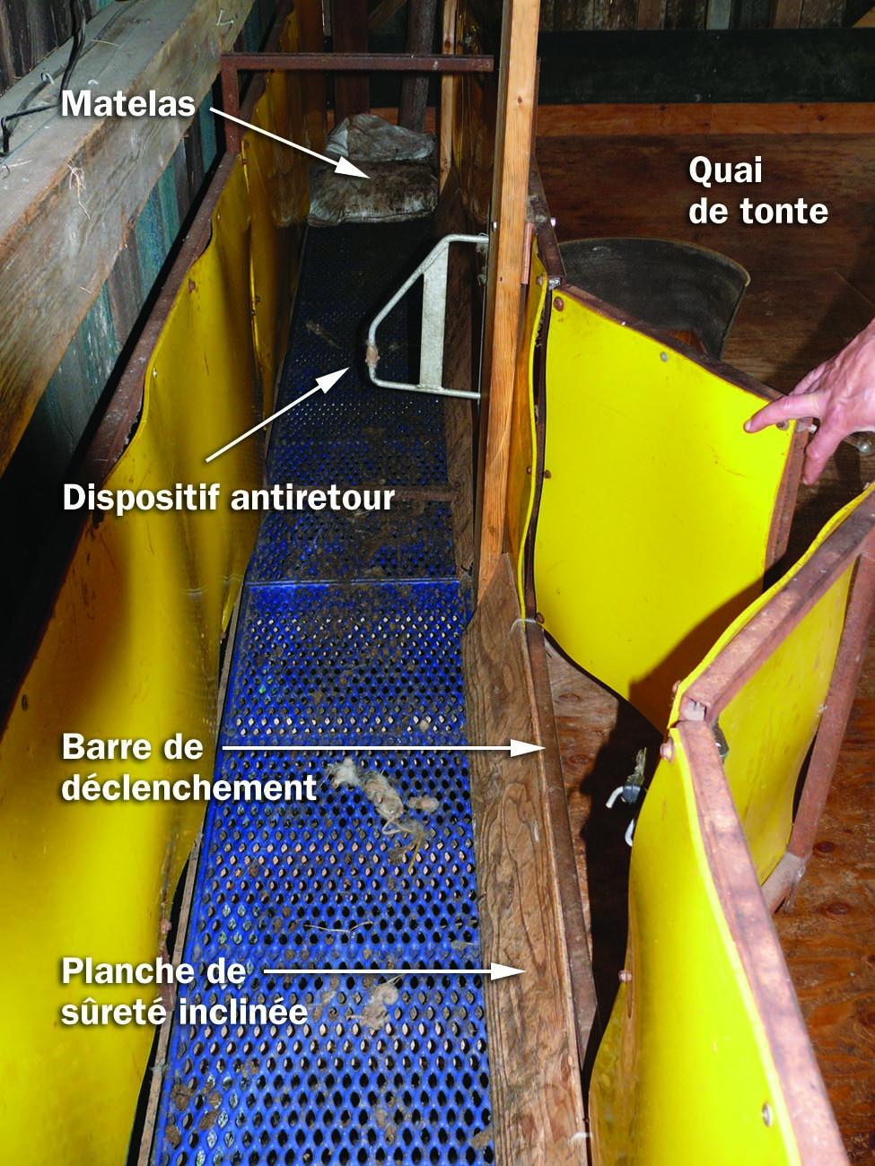 Photo d’un long couloir avec un plancher en treillis d’acier et des parois latérales rembourrées avec une barre de déclenchement à l’extrémité.