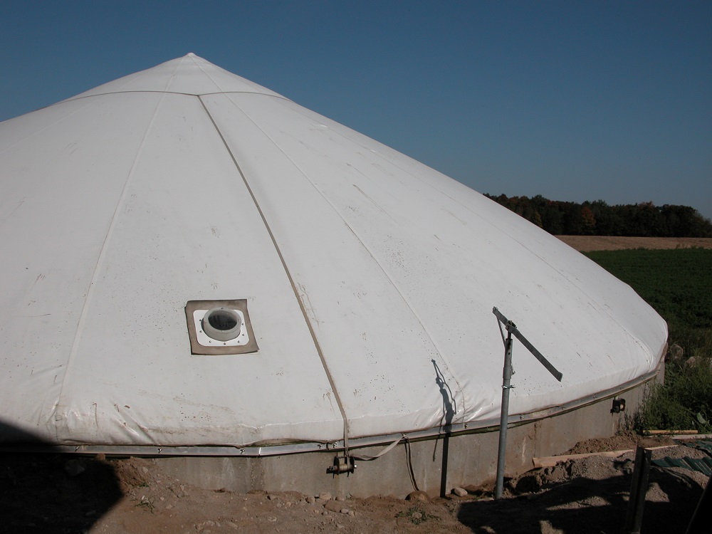 Circular concrete manure tank with an inflated pressurized impermeable soft cover