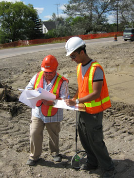 Two men from MTO working with white and red hard hat