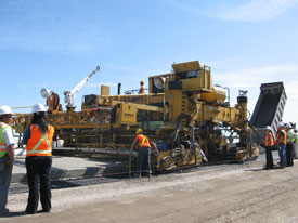 Workers from Ministry of Transportation repairing road with a big machine