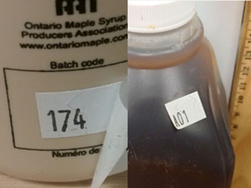 Image of two side-by-side maple syrup containers with stickers displaying a number 174 (left) and A01 (right) as custom lot codes.