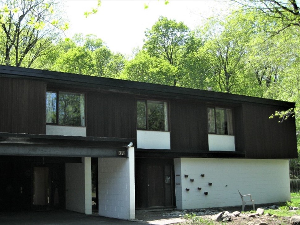 Lipsett House is an excellent example of Modernist residential architecture.  Front of two-storey flat roof house with integrated carport, simple entrance and large floor to ceiling windows.