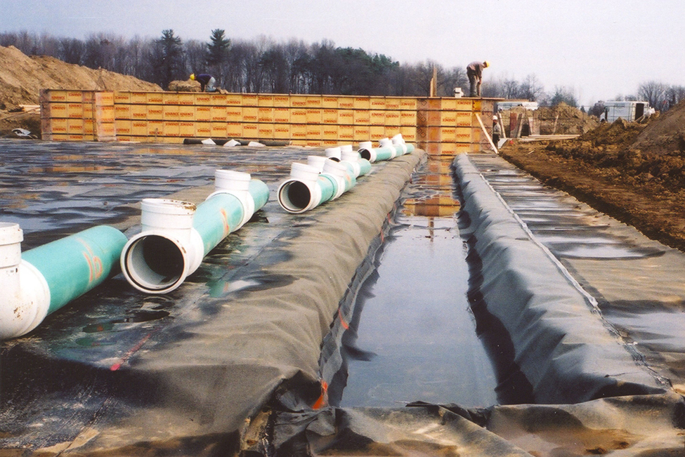 PVC pipe sections lying on the ground waiting to be connected together to form a secure liquid manure transfer system from the in-barn tank to the external manure storage