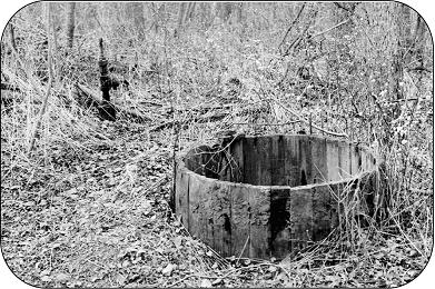 Vieux puits de pétrole avec réservoir de stockage en bois.