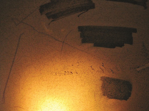 Close-up photo of tank wall that was previously coloured with water soluble marker in several locations being candled from the inside showing crazing.