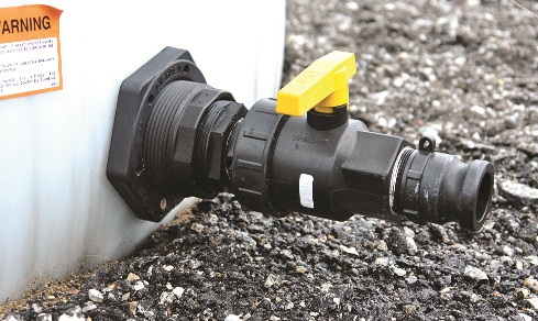 Close-up photo of a lightweight poly ball valve attached to the base of storage tank with an adaptor to attach flexible hose for transferring liquid. This is the preferred piping method, as it does not induce extra stress on the tank wall.
