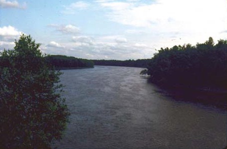 A natural watercourse with a defined bed, banks and sufficient flow.