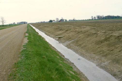 A natural watercourse shows up on an aerial photo (left) and topographical map (right).