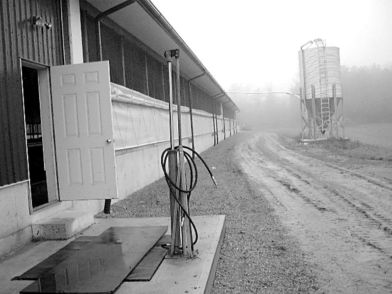 A hydraulically operated gate valve for a gravity drain system, with a dairy barn in the background