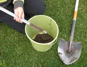Image depicts soil sampling using a tube and shovel
