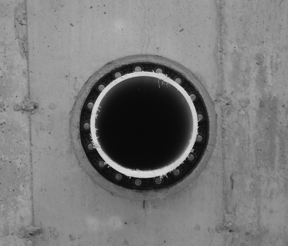 A photo showing a circular, modular seal between the pipe and concrete wall opening, which prevents leakage at the opening.
