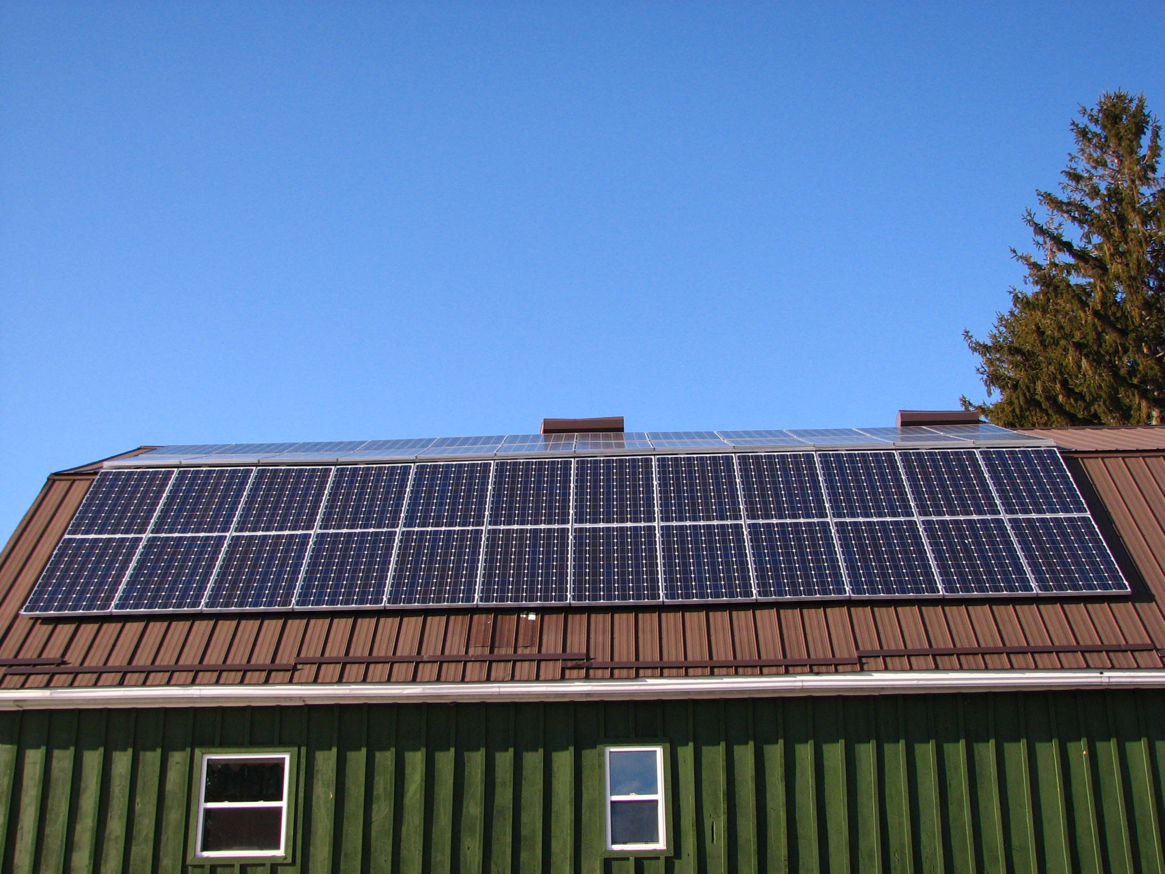 Photo d’une grange avec des panneaux solaires installés sur la toiture