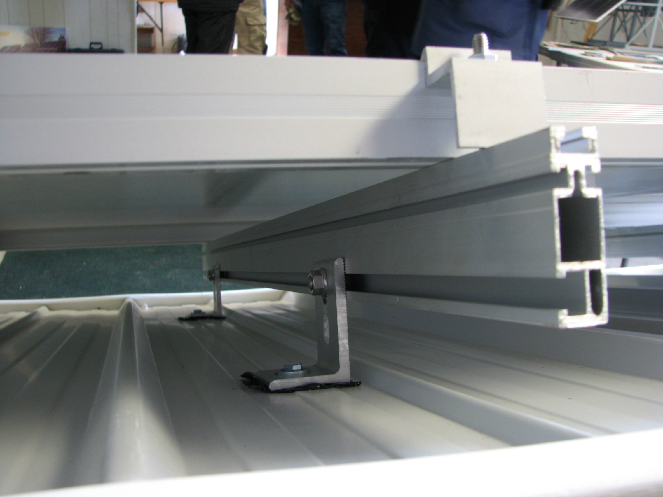 Gros plan d’un panneau solaire installé sur des rails d’aluminium fixés à la toiture à intervalles précis