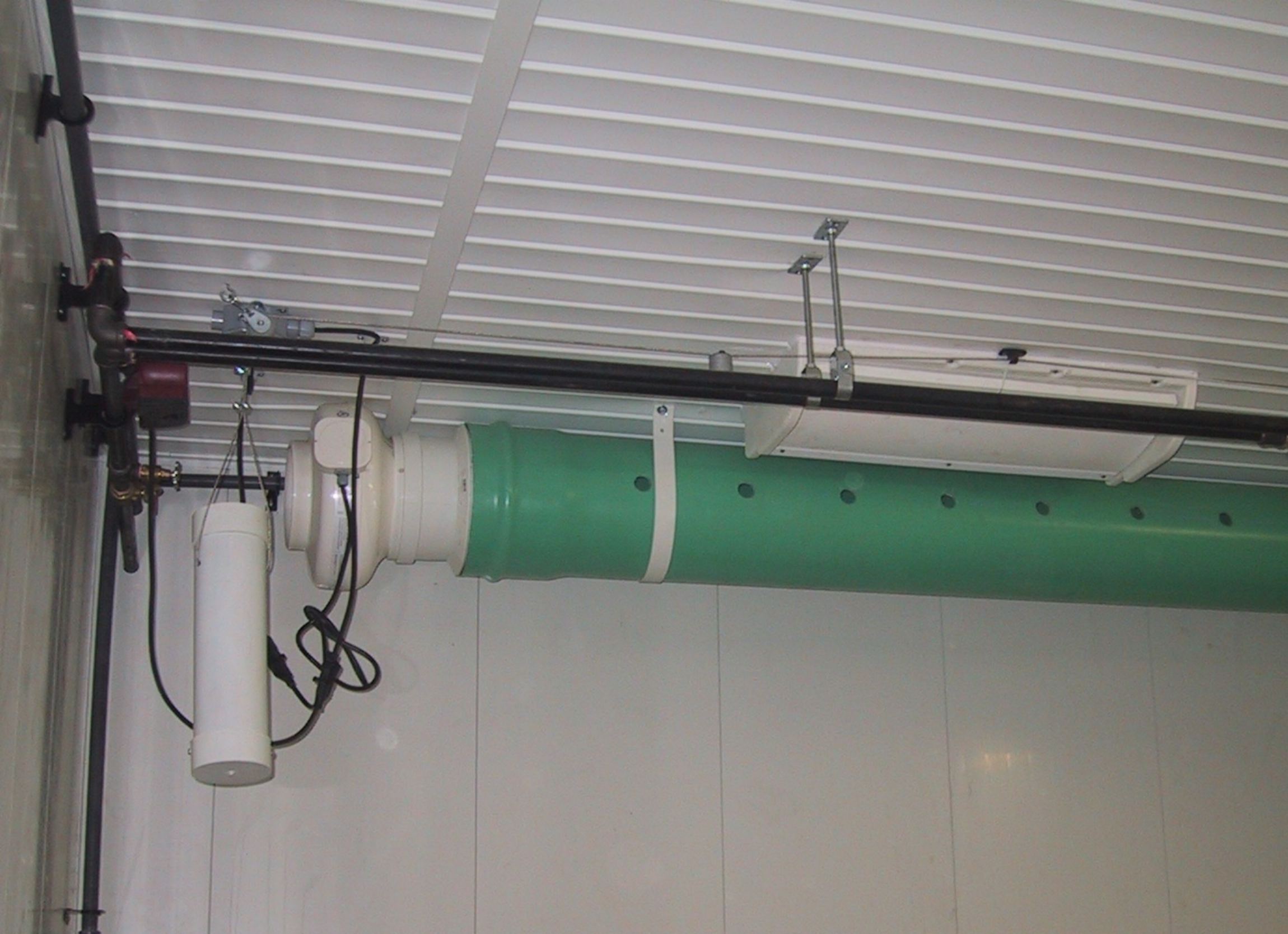 Une installation constituée d’un conduit rigide relié à un ventilateur soufflant et percé de trous de distribution, qui améliore la circulation de l’air.