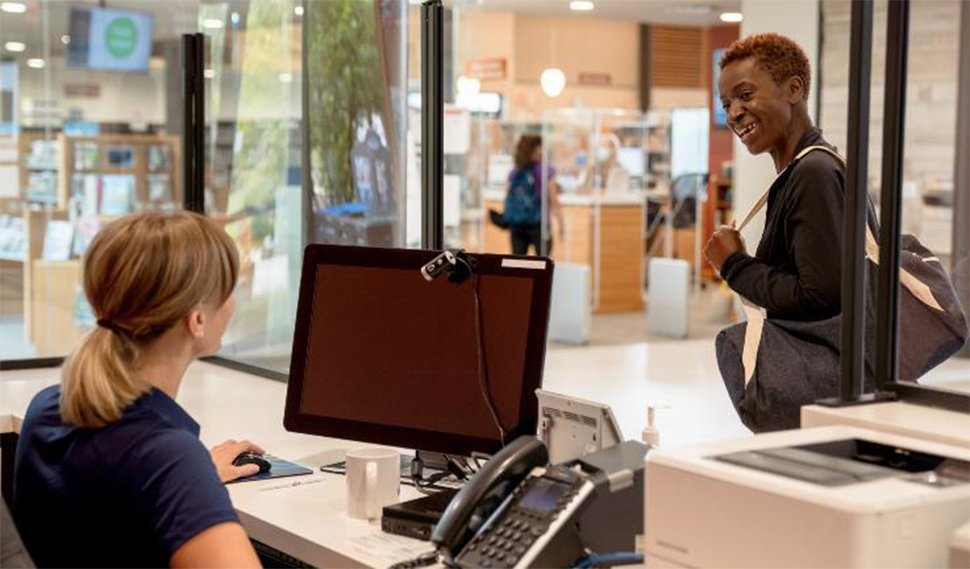 Front desk personnel greeting a customer.