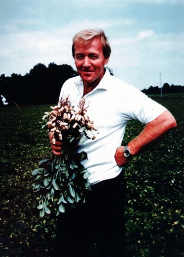 Photo of farmer with peanuts in his field. This photo was provided by Picard’s Peanuts.