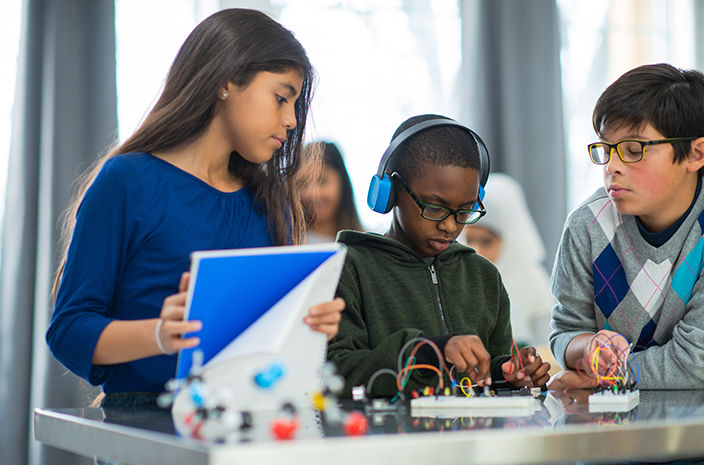 Group of elementary students working with a robotics kit and learning together