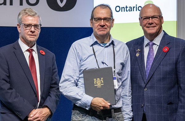Minister Rob Flack and PA John Jordan awarding Peter McClusky with the Promotional  Excellence category Honourable Mention certificate.