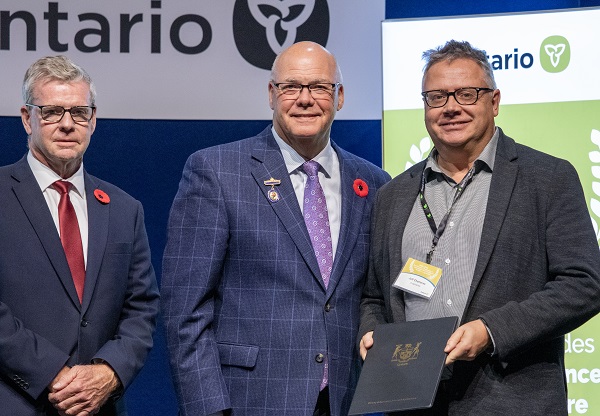 Image of Minister Rob Flack and PA John Jordan awarding Jeffery Chemeres with the Research and Innovation Excellence category Honourable Mention certificate.