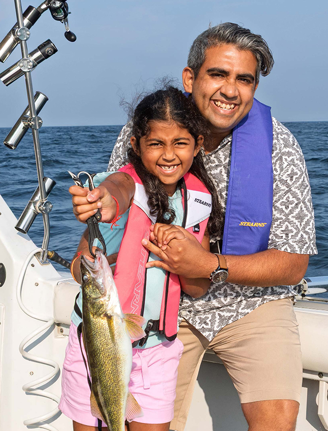 Front cover of the 2026 Fishing Regulations Summary with a father and daughter holding a walleye fishing from a boat