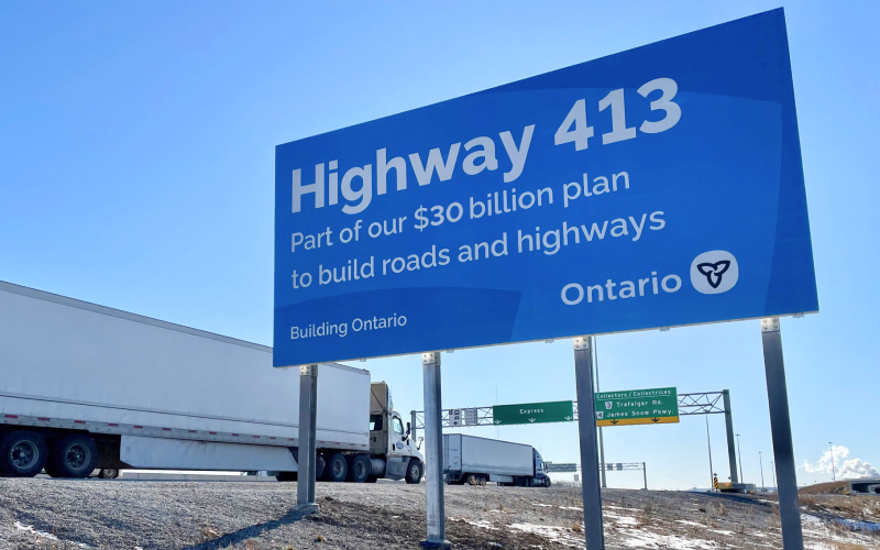 Highway 413 construction sign at the side of highway.