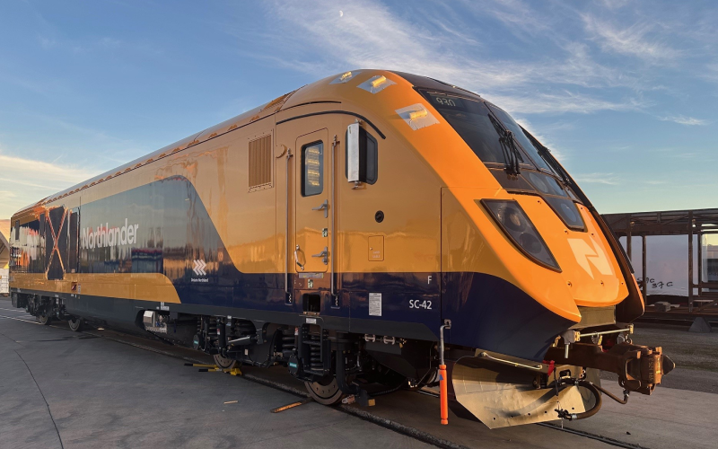 A Northlander passenger train parked on a rail track.