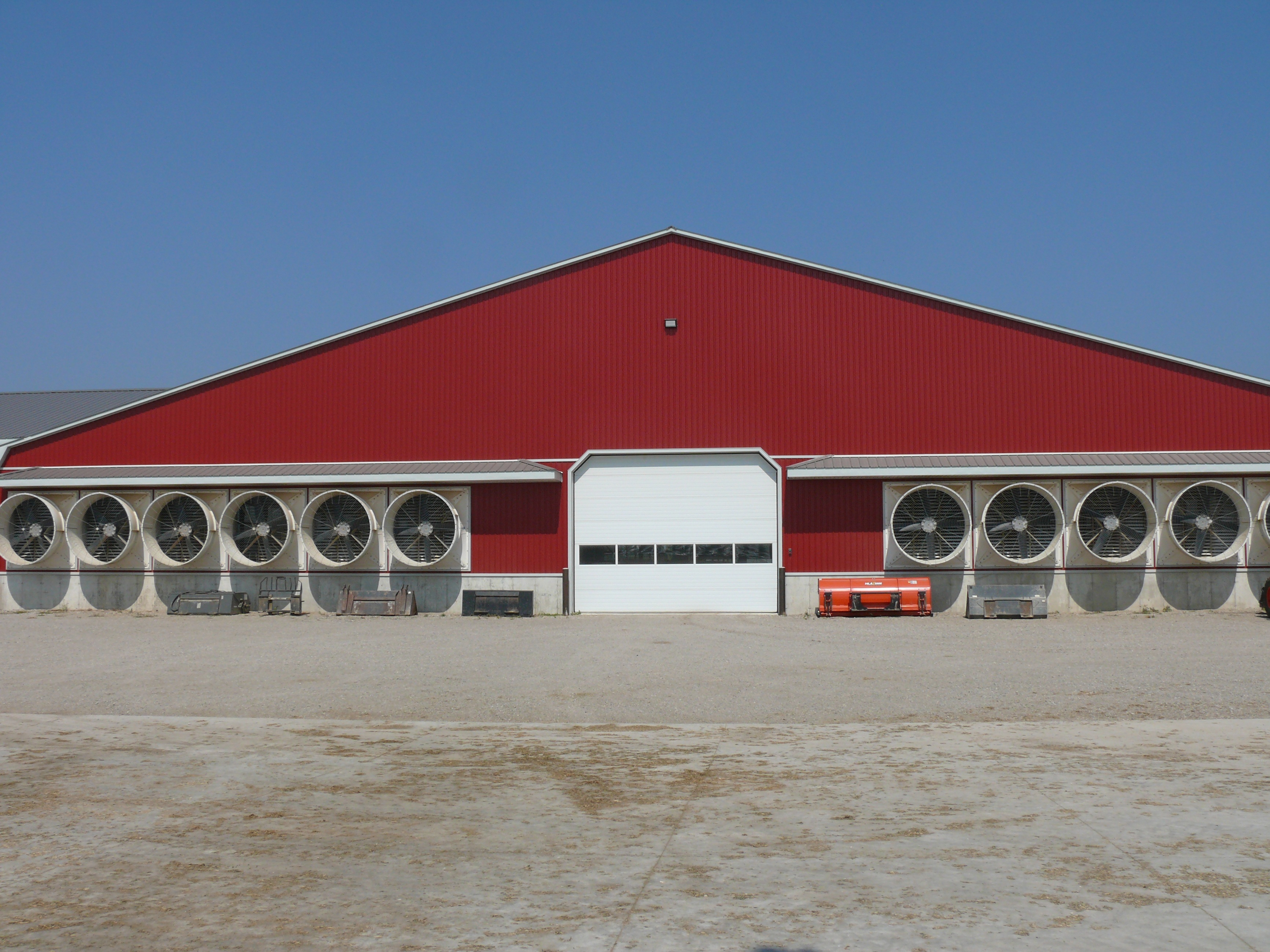 Figure 7 shows the outside of a tunnel-ventilated dairy barn with the end wall covered with fans.