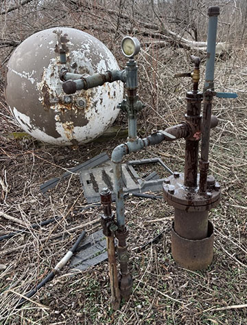 A rusty pipe sticking out of the ground.