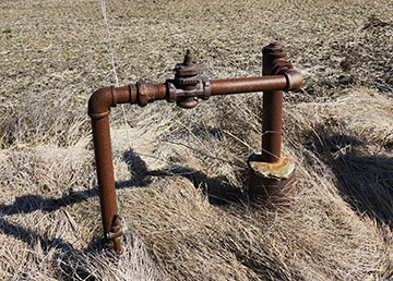 A rusty pipe sticking out of the ground.