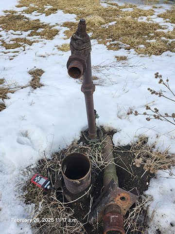 A rusty well with debris pile.